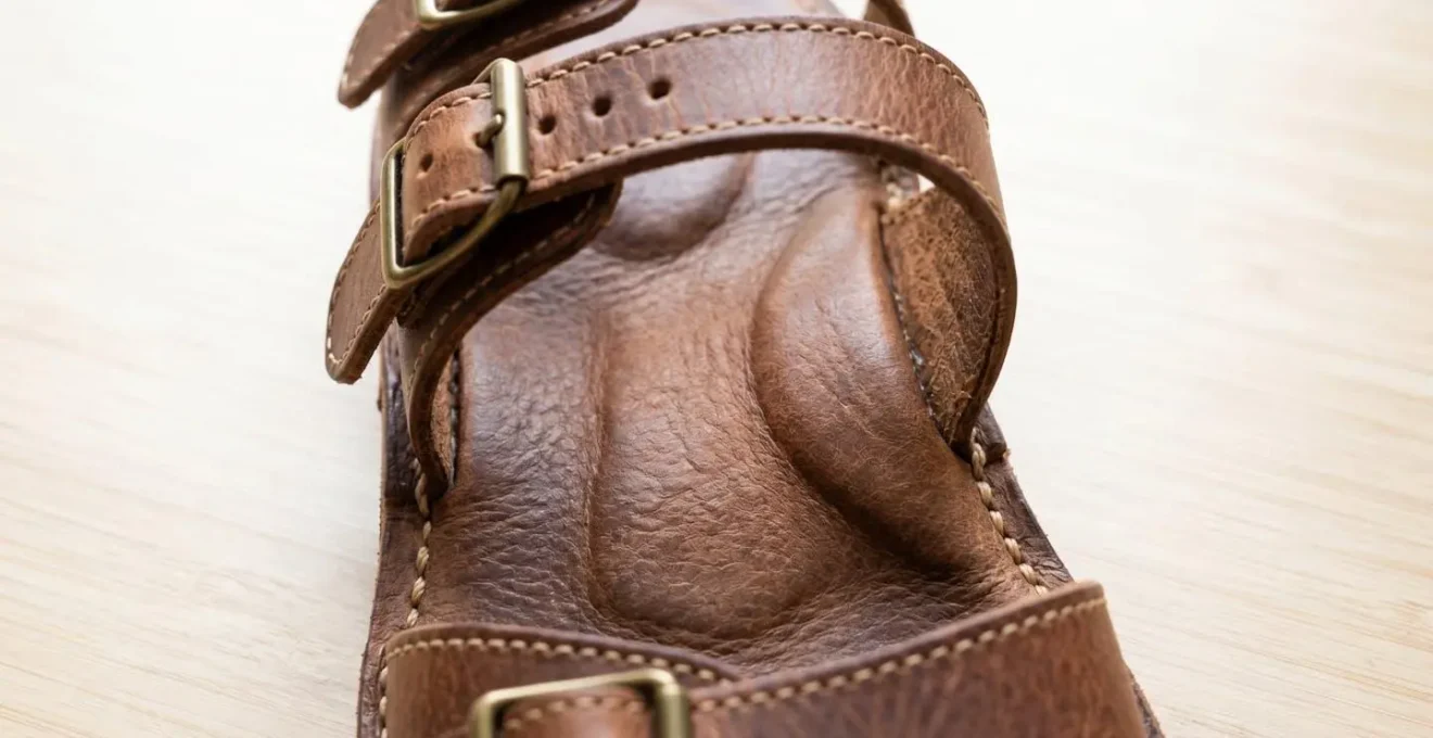 Vue rapprochée d'une semelle anatomique moulée avec brides en cuir ajustables et coutures apparentes de qualité artisanale